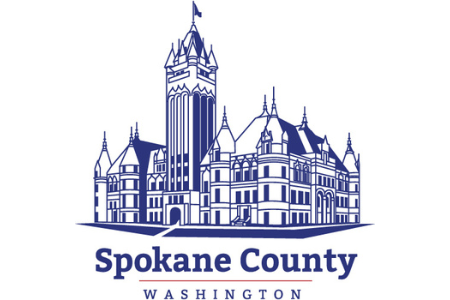 A graphic illustration of a large, historic courthouse with a tall central tower and smaller surrounding spires. The building is depicted in blue outline. Below the illustration, the text reads "Spokane County" in large font and "Washington" in smaller font.