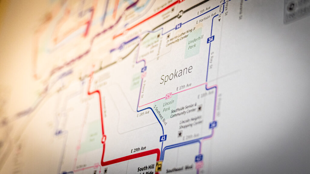 Close-up of a map highlighting the city of Spokane. The image shows various routes in different colors like red and blue, indicating different transportation lines.