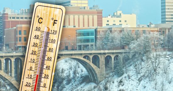 Thermometer over Monroe Street bridge and buildings, showing cold temperatures in Celsius and Fahrenheit.