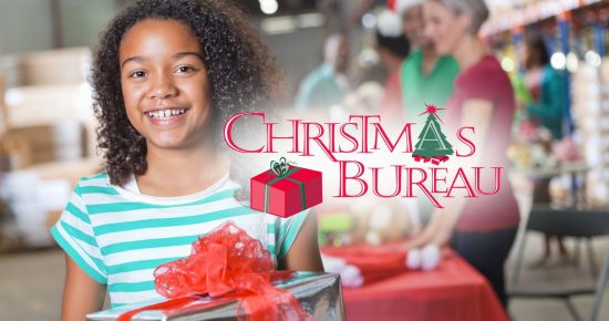 Girl smiling with a gift, standing in a festive setting with "Christmas Bureau" text overlay and people in the background.